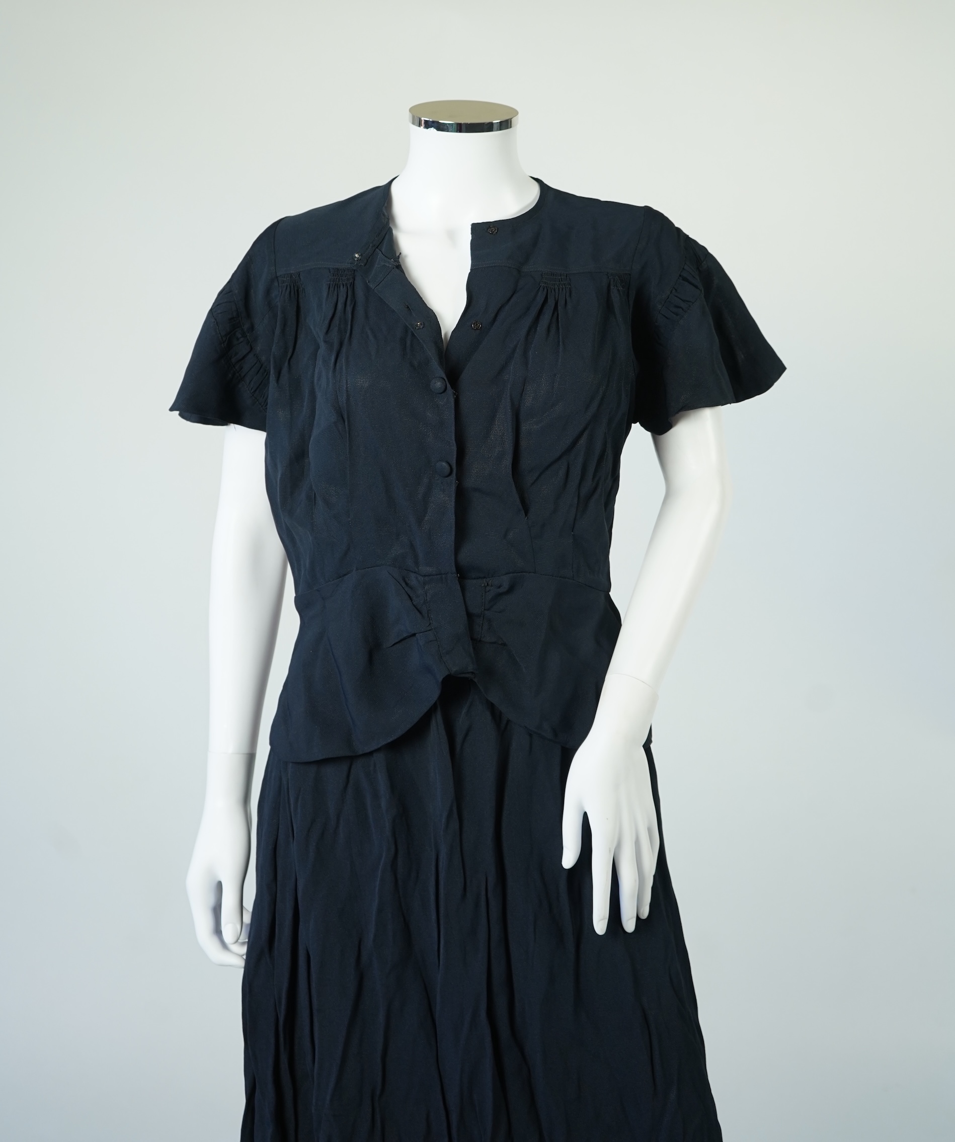 A 1920’s light green silk evening cape with hand batik borders and label: Tito de Canival Mode, together with a navy ladies two piece suit and a maroon satin evening dress. Cape 100cm long. Condition - cape good, navy tw